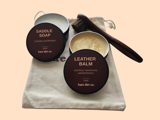 The Foundation glove care kit consisting of a saddle soap, leather balm, soft brush and drawstring storage pouch